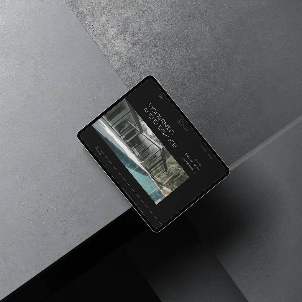 Tablet mockup displaying a modern architecture website design with the text “Modernity and Elegance” on a dark concrete background.